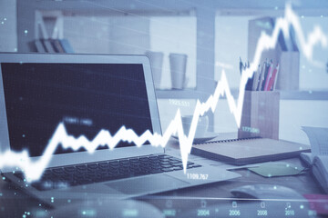 Stock market graph on background with desk and personal computer. Double exposure. Concept of...