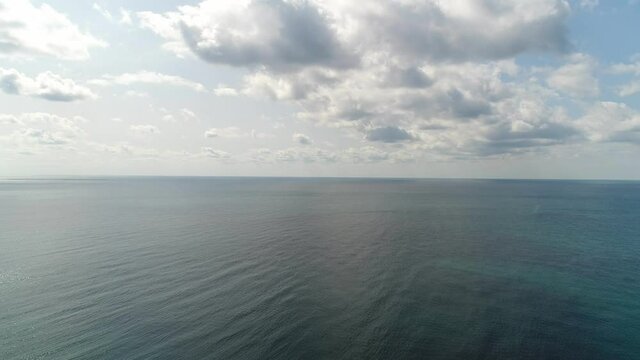 Aerial: a view from a height of the sea against the backdrop of a cloudy sky