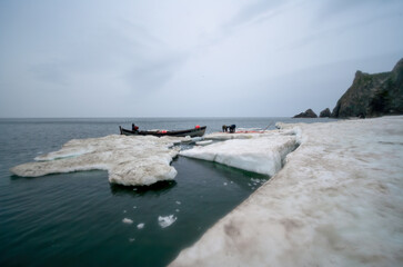 Arctic sea hunters butcher seals on ice in the Bering Strait. Traditional Chukchi and Eskimo hunting for sea animals. The way of life of the indigenous peoples of Chukotka. Far East of Russia. July.