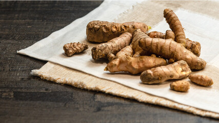 Whole Turmeric roots at white fabric