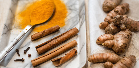 Ingredients for turmeric drink. .Cinnamon sticks, fresh turmeric roots and curcuma powder