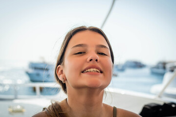 Portrait of a very beautiful cute teenage girl on a background of yachts and a summer sea. Close-up