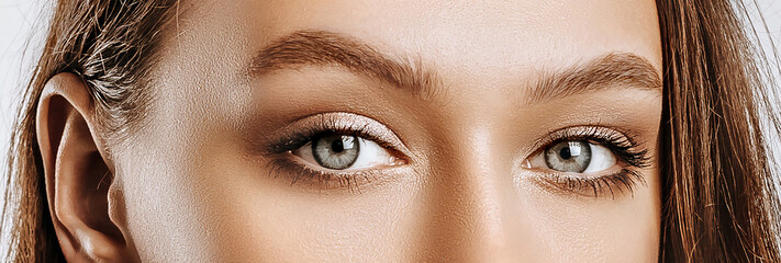 View of a beautiful young brunette girl. Green female eyes with natural makeup. The woman looks...