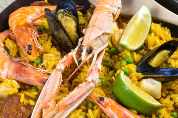 poêle remplie de paella sur une table en bois	