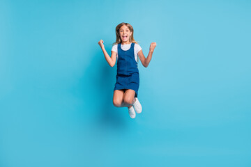 Fototapeta na wymiar Full size photo of hooray cool girl jumping yell wear t-shirt dress shoes isolated on pastel blue color background