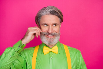 Photo of funny trendy grandpa cunning facial expression curling ideal mustache look flirty side wear green shirt yellow suspenders bow tie isolated vivid pink color background