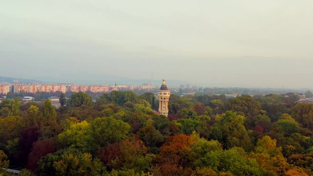 Aerial 4k video about the Margaret island's Water tower. This place is a part of the Open air stage. Amazing autumn and morning mood. Colorful canopies and foggy sky. 