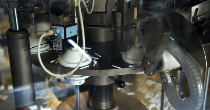 Automatic Tube Filling Machine For Cosmetic Creams - Empty Tubes On The Tunnel From The Loader Conveyed Automatically To Working Disk With Rotary Tube Mould.  - close up