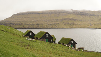 Fototapeta na wymiar Views on Drangarnir Sea Stack and Tindhólmur Island on a cloudy day from the mountains at Bøur Village on the Faroe Islands in Denmark.