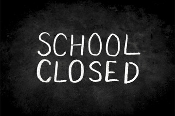 Close up phrase "School Closed" by handwriting white coloured chalk on blackboard. The surface of blackboard is powdery and rough.