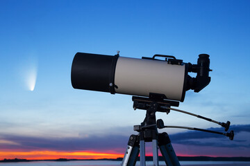 Telescope against the background of the evening sky. A comet in the background.