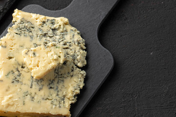 Piece of blue cheese on black stone board