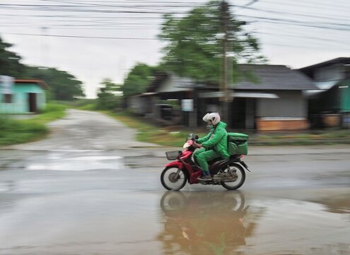 A motorbike is running on a watery road on the road.