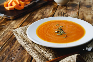 Creamy pumpkin soup on a wooden table