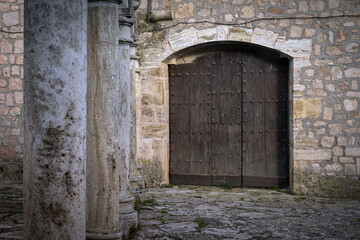 Fototapeta na wymiar Wooden old brown door of a church in Cifuentes, Guadalajara, Spain