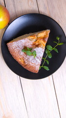 Charlotte, Apple pie with mint sprigs, Apple in a black plate on a wooden table, copy space, close-up, photos,
