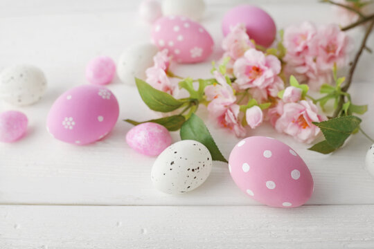 easter eggs and cherry blossom flowers on white background