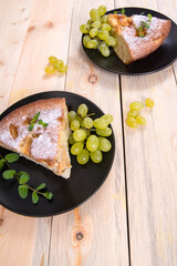 Charlotte, Apple pie with mint sprigs, grapes in a black plate on a wooden table, copy space, close-up, photos,