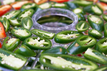sliced green and red chillies in a dehydrator