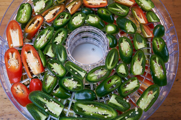 Sliced green and red chillies in a dehydrator top view
