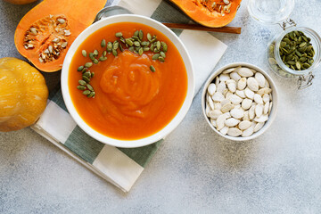 Top view of pureed pumpkin soup in a white bowl on dark table
