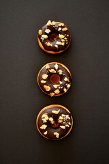 Fototapeta premium Delicious chocolate donuts isolated on a black background.