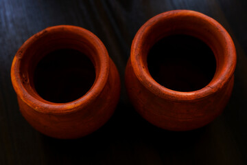 top shot of handmade small clay pots isolated on wooden table