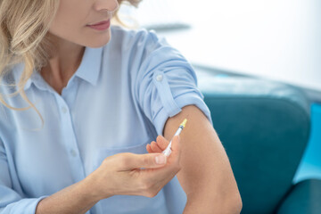 Close-up of female making injection into her arm