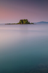 Fototapeta na wymiar Portrait view of Mouse Island, Corfu, Greece, at sunrise. Showing the clear Mediterranean sea in the foreground