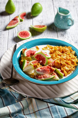 Blue bowl with yogurt, cornflakes, figs, pear