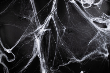 halloween, decoration and horror concept - Decoration of artificial spider web over black background with spiders