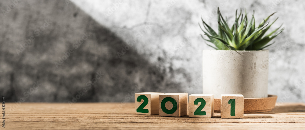 Poster 2021 happy new year on wood block on wood table and concrete wall with sunlight from window.hope new