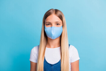 Photo portrait of schoolgirl smiling wear flu mask isolated on pastel blue colored background