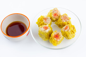 Chinese steamed dumpling 6 piece on plate and sour sauce on a white background.