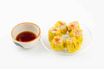 Chinese steamed dumpling 6 piece on plate and sour sauce on a white background.