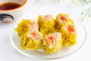 Chinese steamed dumpling 6 piece on plate and sour sauce.