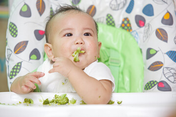 Cute Baby Eating On The Baby Chair