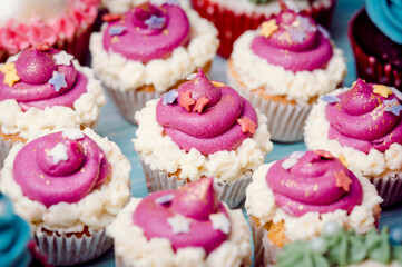 Very nice composition of cupcakes and cakepops with deocrations, colorful, blue background