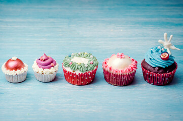 Very nice composition of cupcakes and cakepops with deocrations, colorful, blue background