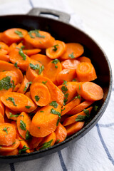 Homemade Sauteed Carrots in a cast iron pan, side view. Close-up.