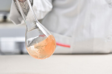 female laboratory assistant mixes liquid in a test tube in the laboratory