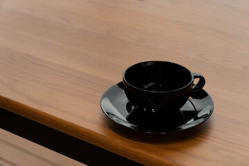 black ceramic cup for coffee hot drink on wood table background