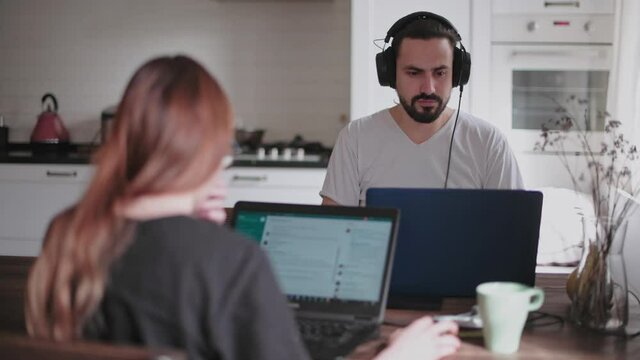 A young couple in love working together on a computer, safely from home.