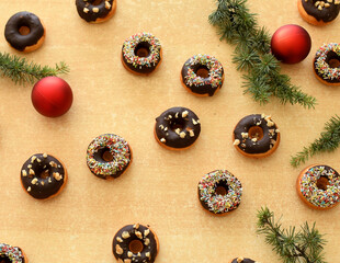 Creative layout made of Christmas tree branches. Flat lay. Nature New Year concept. Delicious chocolate donuts. 