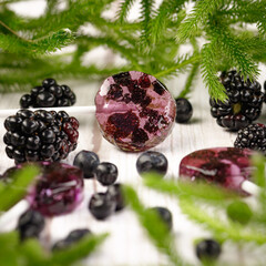 Homemade lollipops made from natural dehydrated bilberry and blackberries on a white wooden background. Healthy vegan vegetarian food with no sweets.