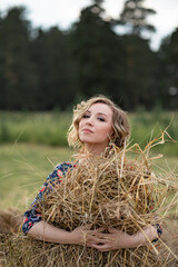 young attractive girl in a dress in a rustic style. Portrait of a beautiful romantic young woman in the countryside at sunset.