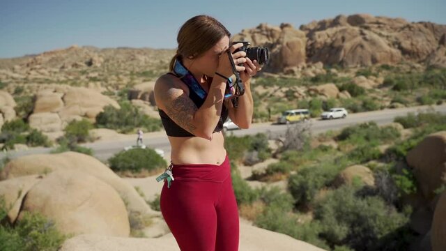 Female photographer taking landscape photos at Joshua Tree national park, California, slow motion