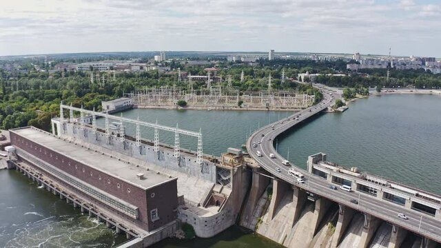 The beautiful river is surrounded by green and fresh vegetation in the city. Dnieper hydroelectric power station in Zaporozhye
