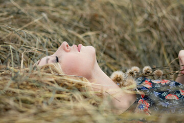 Portrait of a beautiful romantic young woman in the countryside at sunset. young attractive girl in a dress in a rustic style