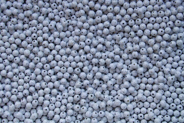 Cluster of white round shaped beads with cross engraved.